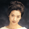 照片中陈慧琳身穿白色睡裙，手捧红色封面书籍，低头看书，非常的恬淡优雅。